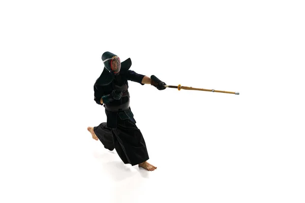 最上階だ プロの剣道選手で 白地の稽古場を背景に竹刀で兜の稽古をしている男 スポーツ 日本文化 アクション 動きの概念 — ストック写真
