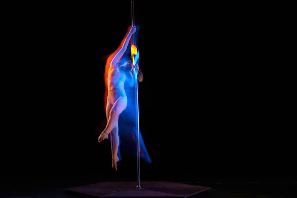 女性气质和性感 年轻姑娘在黑漆漆的演播室背景上表演撑杆舞 有着混合的霓虹灯 运动与舞蹈的概念 动作的美丽 现代风格 — 图库照片