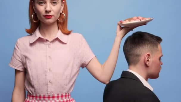 食品流行艺术摄影 年轻女人把早餐披在蓝色的背景上扔在男性肩上 煎蛋和香肠 复古风格复古风格互补的颜色 文字的复制空间 — 图库视频影像