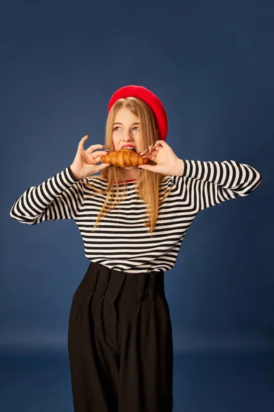 Портрет Красивой Молодой Девушки Красном Берете Позирующей Кусающей Свежий Круассан — стоковое фото