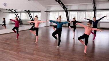Küçük kızlar, çocuklar, içeride koçluk eğitimi alan jimnastikçiler. Esneme ve denge egzersizleri. Spor yaşam tarzı kavramı, çocukluk, eğitim, sağlık, profesyonel spor.