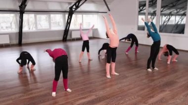 Küçük kızlar, çocuklar, içeride koçluk eğitimi alan jimnastikçiler. Jimnastik köprüsü egzersizi yapıyorum. Spor yaşam tarzı kavramı, çocukluk, eğitim, sağlık, profesyonel spor.