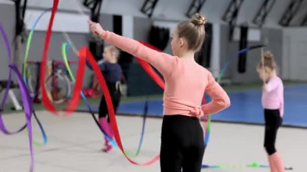 競技会の準備 小さな女の子 リズミカルな体操室内トレーニング リボンで運動を行う スポーツライフスタイル 子供時代 プロスポーツ チャンピオンシップの概念 — ストック動画