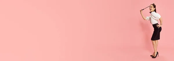 性感的女性形象 穿着正装 在粉红的工作室背景下摆出鞭子 吸引力 生活方式 心情的概念 — 图库照片