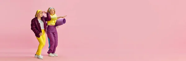 興味を持っている ピンクを背景にスポーツマットでカラフルな制服姿の高齢者スポーツ女性 スポーツライフスタイル ウェルネスの概念 広告のコピースペース — ストック写真