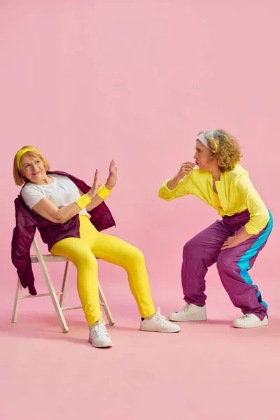 Konkurrens Två Äldre Idrottskvinnor Färgglad Uniform Utbildning Poserar Mot Rosa — Stockfoto