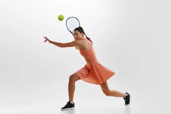 年轻而活泼的女子形象 专业的女子网球选手的训练 在白色的工作室背景下 用球拍击球 职业体育 行动的概念 — 图库照片