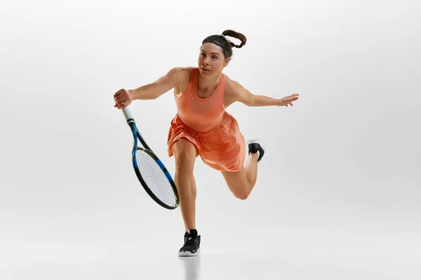 年轻女子的肖像在运动 网球选手的训练背景是白色的工作室 用球拍击球 专业运动 业余爱好的概念 — 图库照片