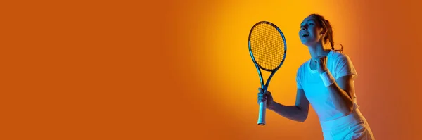 快乐赢得感情 穿着制服的年轻女网球选手在霓虹灯下与橙色工作室背景的球拍合影 专业运动 动作概念 班纳广告的复制空间 — 图库照片