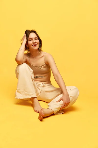 黄色のスタジオの背景にカジュアルな服 上とジーンズにポーズを若い 笑顔の肯定的な女の子の肖像画 美しさ 身体とスキンケア フィギュア フィットネス ウェルネスの概念 — ストック写真