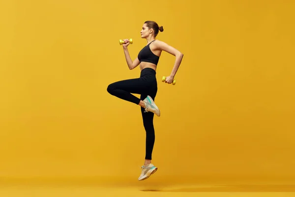 年轻漂亮姑娘在运动服训练中的动态形象 在黄色工作室背景下奔跑 有氧运动课体育 健康和积极的生活方式 健康的概念 — 图库照片