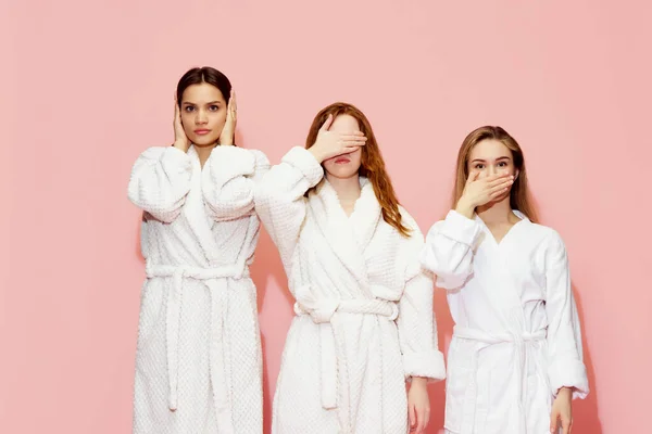 Tři Dívky Županech Zakrývaly Oči Ústa Uši Pózovaly Růžovém Pozadí — Stock fotografie