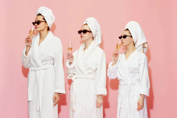 Hen党 三个年轻的女孩 穿着毛巾 浴衣和太阳镜的朋友 在粉红的工作室背景下喝香槟 Spa 放松的概念 — 图库照片