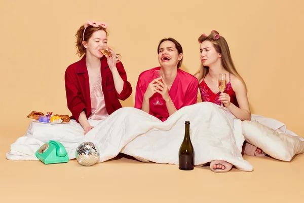哭了朋友的支持 穿着睡衣的少女们坐在毛毯下 一边聊天一边喝酒 帮助沟通 放松的概念 — 图库照片
