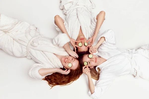 Красивые Молодые Девушки Халатах Лежат Кругу Огуречной Маской Глазах Белом — стоковое фото