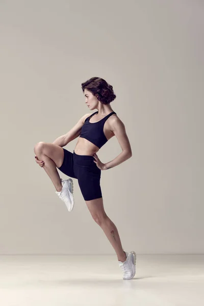 튼튼하고 날씬하며 검은색 제복을 배경에 대항하는 여성의 초상화 스포츠 생활의 — 스톡 사진