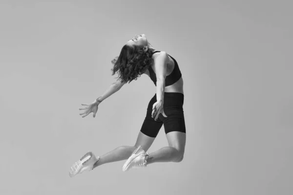 黑色和白色的图像 年轻的运动女子 身材苗条 穿着运动服训练 做伸展运动 运动生活方式 身体护理 健康的概念 — 图库照片