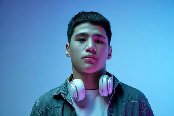 Portret Młodego Przystojnego Azjaty Słuchawkami Uważnie Patrzącego Kamerę Pozującego Niebieskie — Zdjęcie stockowe