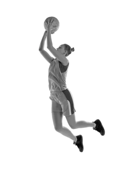 ジャンプ中の若いアスレチック少女の黒と白のイメージ 白のスタジオの背景に対してバスケットボールをプレイ プロスポーツ 健康的なライフスタイル アクションと運動の概念 — ストック写真