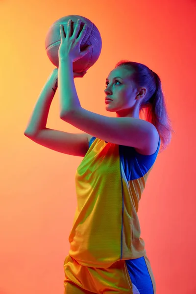 若い濃縮された女の子 均一な女性バスケットボール選手 白いスタジオの背景にボールでポーズ プロスポーツ 健康的なライフスタイル アクションと運動の概念 — ストック写真