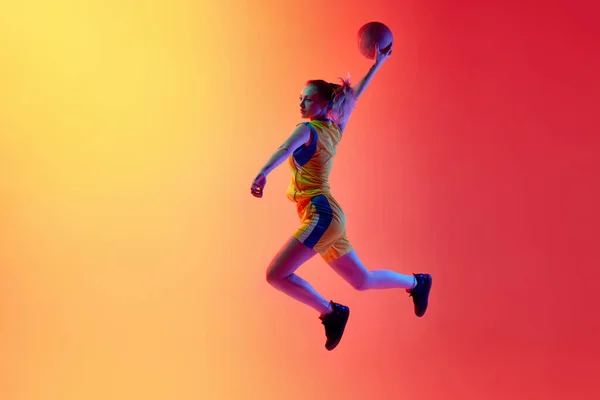 スラムダンク ゲーム投げボール中の動きでアクティブな女性バスケットボール選手のダイナミックなイメージは 白いスタジオの背景に対して再生します プロスポーツ 健康的なライフスタイルの概念 — ストック写真