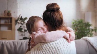 Sevgi ve özen gösteriyorum. Genç bir kadın, annesi küçük gülümseyen kızına sarılıyor. Gündüzleri evde vakit geçirmek. Aile ilişkisi kavramı, annelik ve çocukluk, sevgi, şefkat.