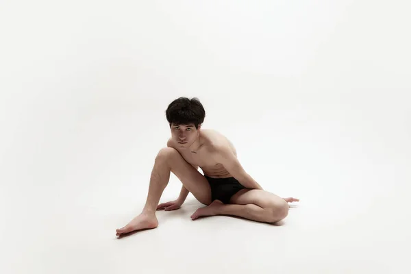 演播室里的形象是年轻英俊的亚裔男子穿着内衣裤赤身裸体地躺在地板上 与白色背景相映衬 男性身体美学 男性美的概念 — 图库照片