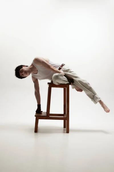 Sztuka Fotografii Młody Handsoem Pozujący Spodniach Leżący Wysokim Krześle Patrzący — Zdjęcie stockowe