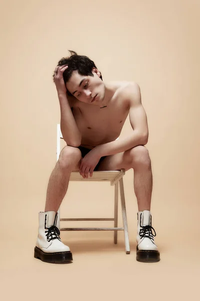 Pozorný Pohled Mladý Muž Sedící Židli Bez Trička Botách Držící — Stock fotografie