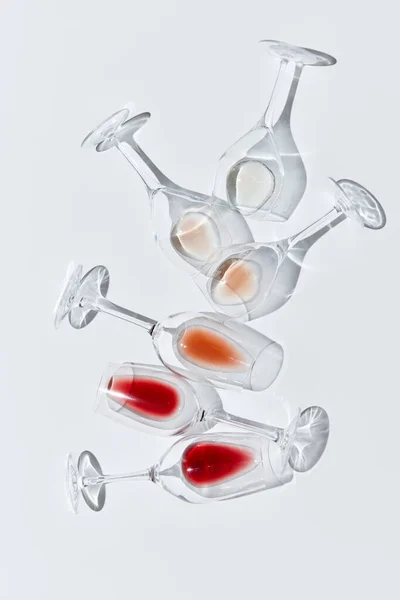 Art of traditional wine taste. Glasses with drops of different red, white and rose wine against white background. Vertical layout. Concept of taste, alcohol, wine degustation, winemaking. Flat lay