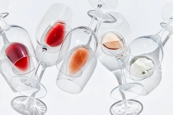 Traditional wine taste and winery. Glasses with different delicious red, white and rose wine against white background. Concept of taste, alcohol, wine degustation, variety, winemaking. Flat lay