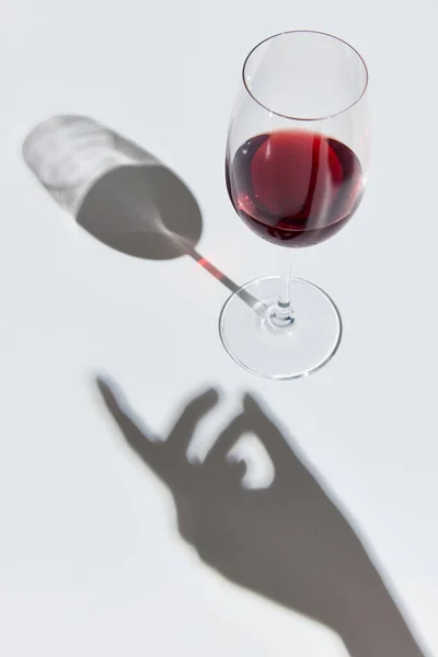 ガラスのおいしい赤ワインで 女性の手の影と白の背景に立っていっぱい お祝いだ アルコール ワインの劣化 ワイン製造の概念 — ストック写真