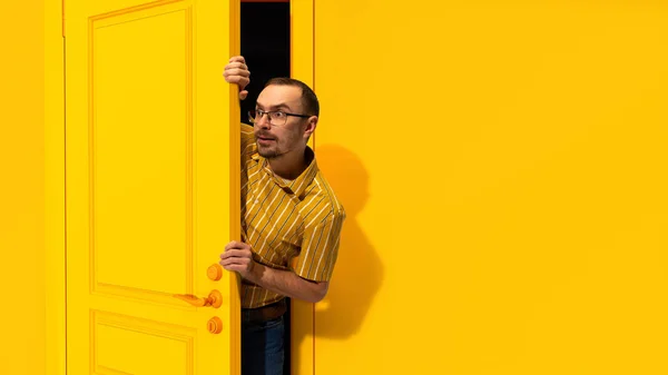 Young Man Glasses Peeking Out Yellow Door Looking Excitement Shock — Stock Photo, Image