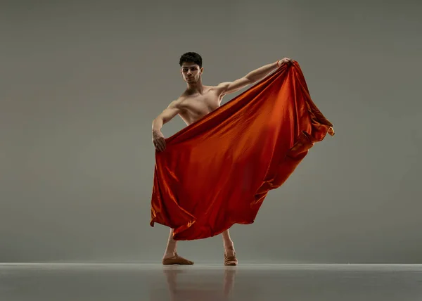 Młody Przystojny Mężczyzna Tancerz Baletowy Wykonujący Spektakl Czerwonej Jedwabnej Tkaniny — Zdjęcie stockowe