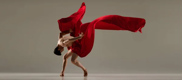 才能ある演奏だ 灰色のスタジオの背景に赤い絹の生地で踊るハンサムな男 バレエダンサー 古典舞踊 インスピレーション 創造性 ファッション 美しさ 振付の概念 — ストック写真