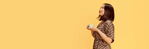 Portret Młodej Azjatki Stojącej Filiżanką Kawy Żółtym Tle Studia Marzycielska — Zdjęcie stockowe