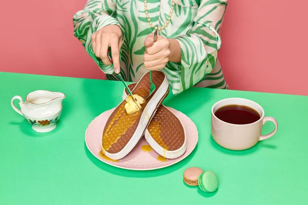 女手用叉子和刀切割超现实的华夫饼运动鞋和融化的黄油和蜂蜜与粉红工作室背景 食品流行艺术摄影 复古风格的概念 创造性的远见 — 图库照片