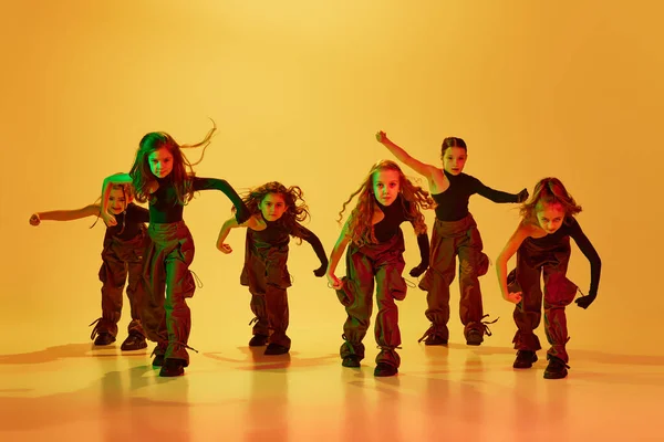 예술적 아이들 운동복을 소녀들 노란색 스튜디오 배경을 배경으로 힙합을 연주하고 — 스톡 사진