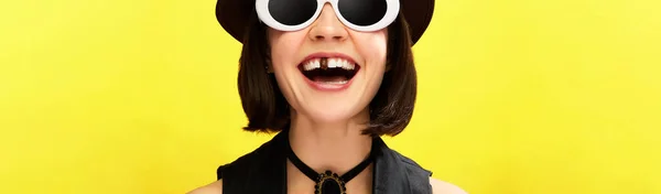 戴着太阳镜的女人带着一颗巧克力牙在黄色背景下微笑的剪影 流行艺术的概念 创造力 牙齿护理 班纳广告的复制空间 — 图库照片