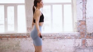 Cılız, fit vücutlu, renkli spor giyim eğitimli çekici bir genç kız. Gündüz vakti ipin üzerinden atlıyor. Spor yaşam tarzı, güzellik, vücut ve sağlık hizmetleri, fitness kavramı