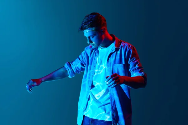 Młody Człowiek Stojący Cyfrowymi Światłami Neonowymi Odbitymi Twarzy Ciele Niebieskim — Zdjęcie stockowe