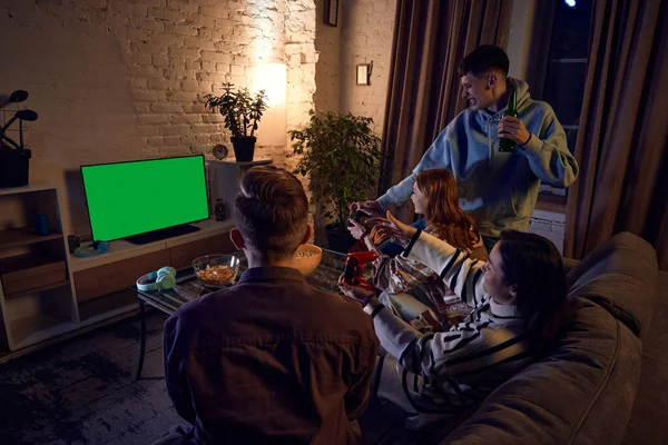 若い男性と女性のグループは 夕方に自宅に集まり ソファに座って コンソールでオンラインビデオゲームをプレイします レジャー活動 楽しみの概念 — ストック写真