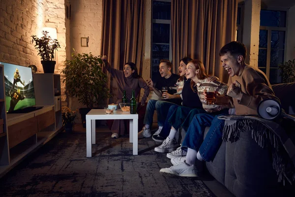 勝利試合だ スポーツファンのグループ 夕方に自宅でソファに座っている友人やテレビでアメリカのサッカーゲームの翻訳を見て レジャー活動 感情の概念 — ストック写真