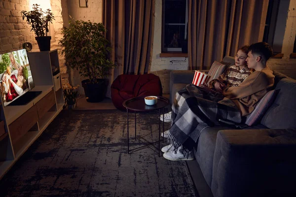 若い美しいカップル 男性と女性は夜に自宅で一緒に時間を過ごし ソファに座ってロマンチックな映画を見ています 関係の概念 レジャー活動 楽しみ — ストック写真