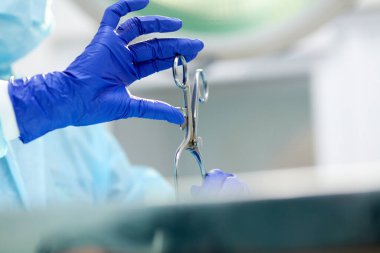Doktorlar, cerrahlar, profesyonel tıbbi aletleri tutan eller. Koruyucu eldiven ve önlük giyen bir doktor. Tıp, hastane, sağlık, tedavi, meslek kavramı