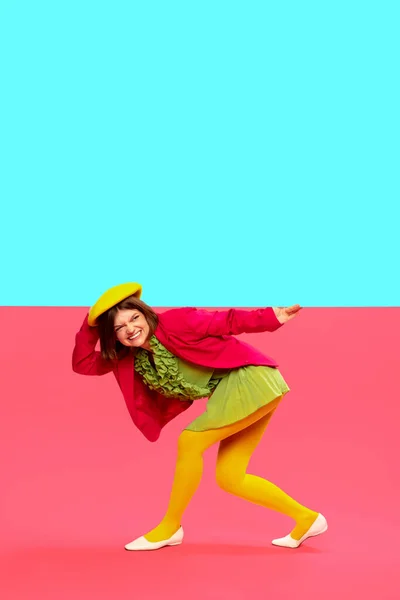 Challenges and difficulties. Young stylish girl in colorful clothes over vivid blue and pink background. Pop art style. Art, creative vision, fashion concept. Complementary colors. Copy space for ad
