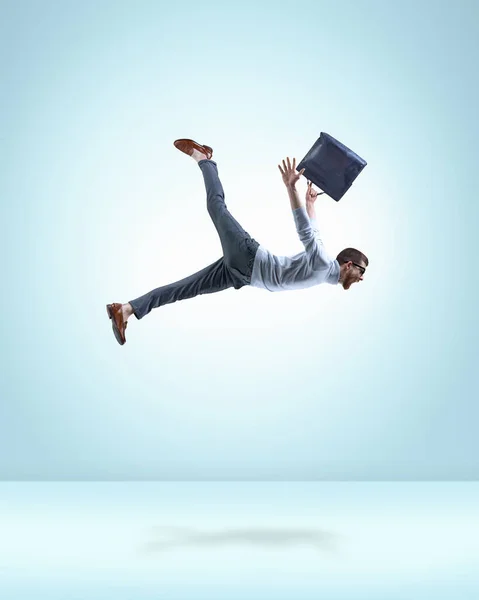 モチベーションと野心的な若い男 ライトブルーの背景に飛んでブリーフケース付きの正式な摩耗で従業員 プロの成長 内なる世界 シュールレアリズム 創造性の概念 — ストック写真