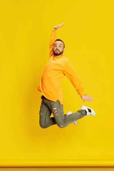 Sıradan Kıyafetlerle Atlayan Parlak Sarı Arka Planda Poz Veren Sakallı — Stok fotoğraf