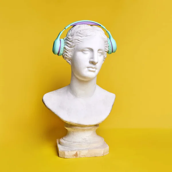 Starożytne Popiersie Posągu Niebieskich Słuchawkach Żółtym Tle Styl Życia Muzyki — Zdjęcie stockowe