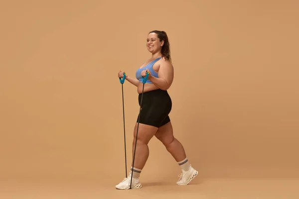 Νεαρή Υπέρβαρη Γυναίκα Χαμογελά Εκπαιδεύεται Αθλητικά Ρούχα Εξοπλισμό Γυμναστικής Εκτείνεται — Φωτογραφία Αρχείου